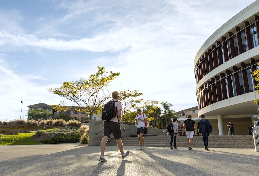 Students walking toward the library in the sun