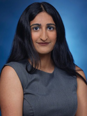 Woman with black hair in front of a blue background