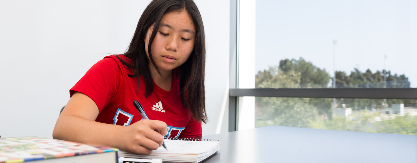 Student writing in a notebook