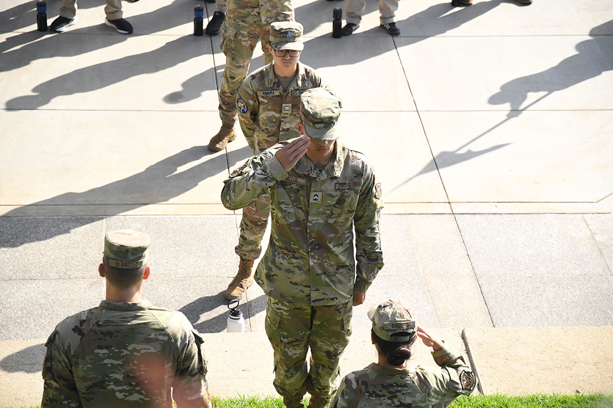 AFROTC cadets in combat attire standing in formation and saluting