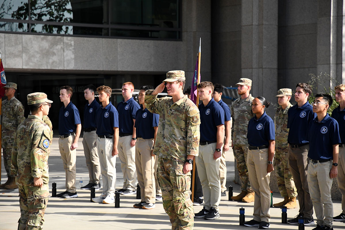 AFROTC cadets in combat attire standing in formation and saluting