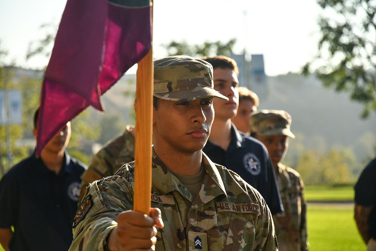 AFROTC cadets in combat attire standing in formation and holding the US Air Force flag