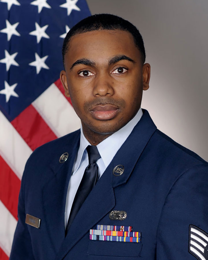 Isaiah Thomas in uniform and standing in front of the American flag