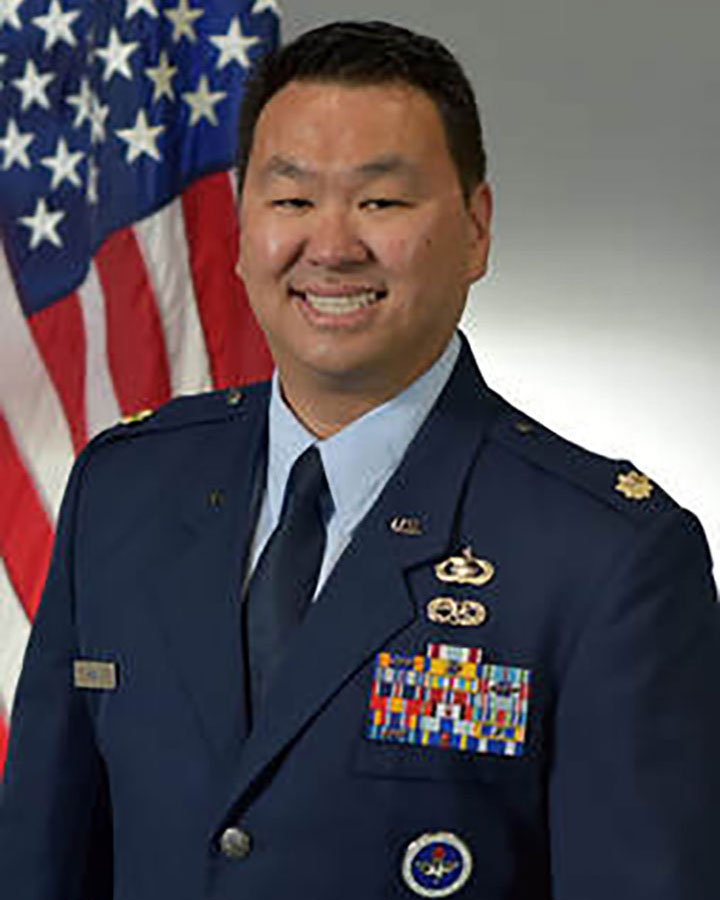 Kevin Kim in uniform and standing in front of the American flag