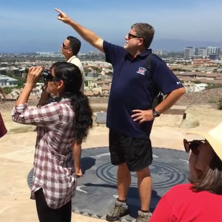 A CURes team member calling a groups attention to something from the LMU Tongva Memorial