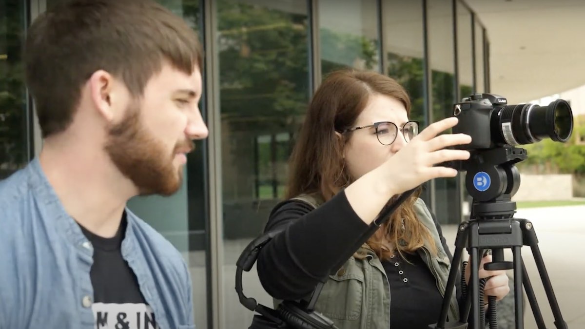 male and female student using a camera on a tripod