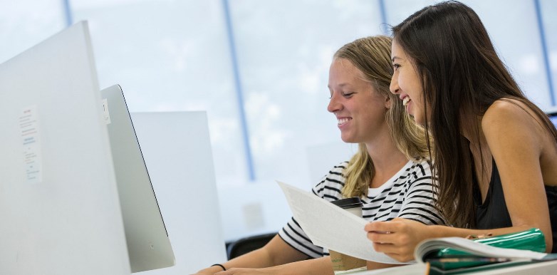 Two young women at a computer.